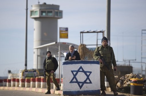 Bewaffnete Soldaten stehen nahe einer Busstation bei Gush Etzion. Foto: dpa