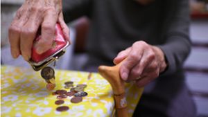 Eine Rentnerin schüttet den Inhalt ihres Geldbeutel auf den Küchentisch: Eine steigende Zahl von Menschen braucht staatliche Unterstützung im Alter, weil die eigene Rente nicht ausreicht. Foto: dpa/Felix Kästle