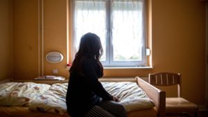 Eine Frau sitzt in einem Frauenhaus auf einem Bett. In Deutschland fehlen über 13.000 Frauenhausplätze (Symbolfoto). Foto: picture alliance/dpa/Maja Hitij