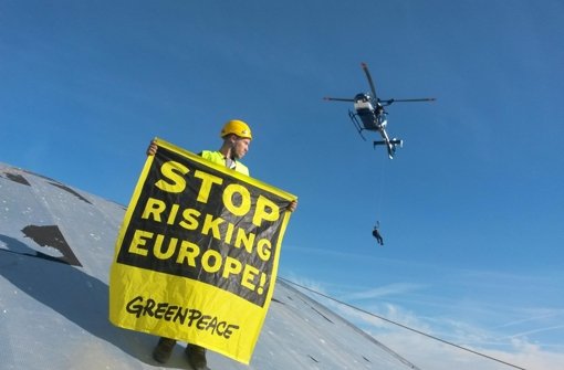 Ein Greenpeace-Aktivist protestiert auf dem Atomkraftwerk Fessenheim in Frankreich - in Belgien könnten viele im Winter – zumindest stundenweise – ohne Strom dastehen.  Foto: Greenpeace