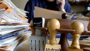 Ein Beamter sitzt telefonierend an seinem Arbeitsplatz Foto: dpa