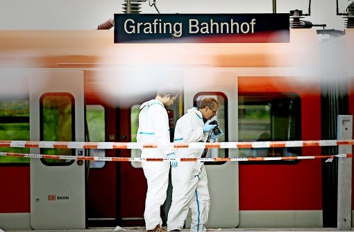 Zwei Forensiker der Polizei sichern Spuren am Bahnhof von Grafing. Foto: Getty