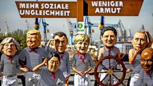 Aktivisten haben sich mit Masken von G-20-Regierungschefs an den Landungsbrücken Hamburg platziert. Foto: dpa