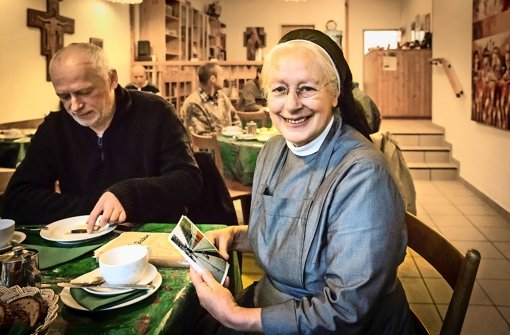 Schwester Margret leistet einem Gast in der Franziskusstube Gesellschaft Foto: Achim Zweygarth