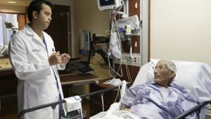 Patient Frank Reyes im Gespräch mit seinem Chirurgen vor der OP. Foto: AP