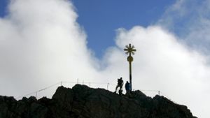 Der Berg ruft: Wenn das Gipfelkreuz nach anstrengendem Aufstieg erreicht ist, kann man zu Recht stolz auf sich sein. Doch darf man auf es hinauf klettern? Foto: dpa
