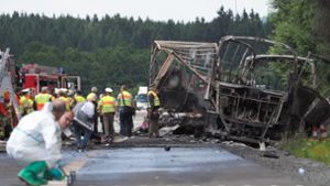 Experten der Spurensicherung untersuchen die ausgebrannten Überreste des Unglücksbusses. Foto: dpa