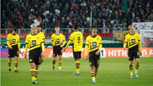Enttäuschte BVB-Spieler laufen nach dem 1:1 in Augsburg vom Platz. Foto: AFP/MICHAELA REHLE