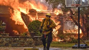 Kampf gegen Buschbrände in Kalifornien: Ein Feuerwehrmann ist in Anaheim vor einem brennenden Haus im Einsatz. Foto: Orange County Register via ZUMA/dpa