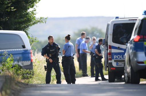 Polizisten warten an einem gesperrten Feldweg im Stadtteil Erbenheim. Nach dem Fund einer weiblichen Leiche in Wiesbaden geht die Polizei ersten Erkenntnissen zufolge von einem Gewaltverbrechen aus. Foto: dpa