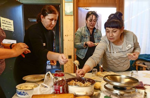 Serap Balles (Im Hintergrund) bereitet mit den Frauen die Füllungen vor. In der Küche (Foto rechts) schöpfen Viktoria Holota (links) und Olena Iastrebynska die Wareniki ab. Foto: Simon Granville