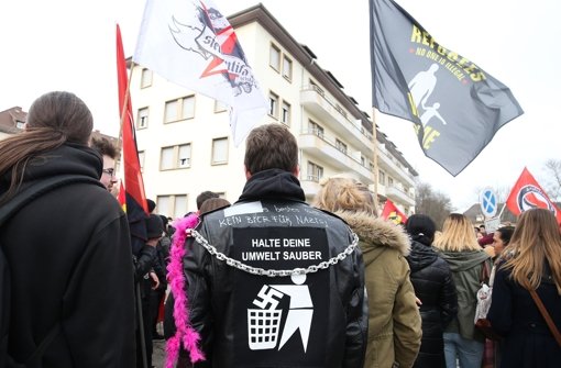 Ein Kundgebungsteilnehmer bringt bei einer Demonstration vor einer Flüchtlingsunterkunft  seinen Protest gegen Rechtsextreme mit einem Anti-Nazi-Jackenaufdruck „Halte Deine Umwelt sauber“ zum Ausdruck. Foto: dpa