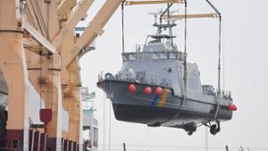 Ein Küstenschutzboot für Saudi-Arabien wird in einem Hafen in Mecklenburg-Vorpommern auf ein Transportschiff verladen. Foto: ZB