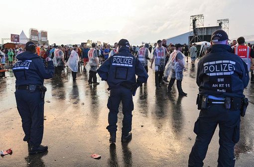 Polizisten sperren nach einer Unwetterwarnung im Regen das Festivalgelände ab. Foto: dpa