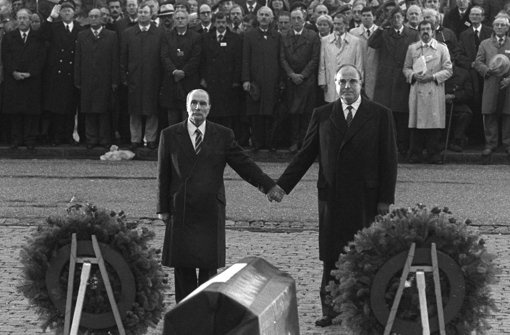 Historische Geste: Der französische Staatspräsident Francois Mitterrand und der deutsche Bundeskanzler Helmut Kohl (re.) reichen sich am 22. September 1984 über den Gräbern von Verdun die Hand. Foto: dpa