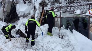 Rettungskräfte schaufeln sich durch die Schneemassen, die das Hotel unter sich begraben haben. Foto: ANSA/AP