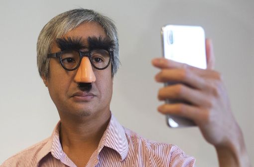 AP-Reporter Anick Jesdanun zeigt, wie das iPhone X auch mit teilweise verdecktem Gesicht noch entsperrt werden kann. Foto: AP