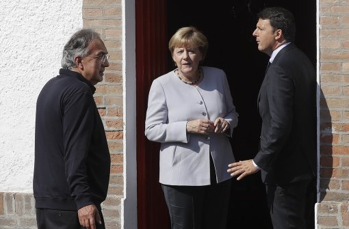 Begrüßt wurde Angela Merkel bei ihrem Besuch im italienischen Maranello von Präsidenten des Unternehmens Fiat Chrysler Automobiles, Sergio Marchionne (links), und Matteo Renzi. Foto: AP