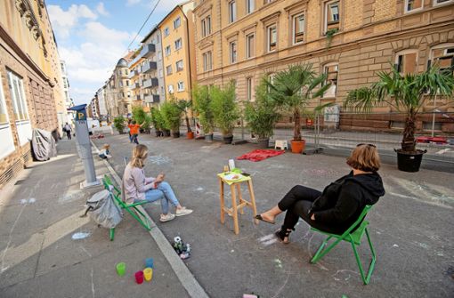 Erwachsene sitzen auf der Straße, Kinder spielen: Im Jahr 2021 wurde die Augustenstraße anlässlich der Stuttgarter Mobilitätswoche schon einmal zum „Superblock West“. Foto: Lichtgut//Leif Piechowski