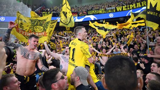 Dortmunds Marco Reus (M) jubelt mit den mitgereisten Fans über den Sieg bei Paris Saint-Germain. Foto: Robert Michael/dpa