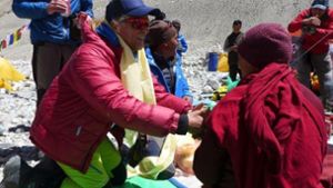 Der Lama (spirituelle Lehrer) des nahen Rongpu-Klosters erteilt Andy Holzer (in der roten Daunenjacke) im Basislager den traditionellen buddhistischen Segen für seine Everest-Unternehmung. Foto: Wolfgang Klocker