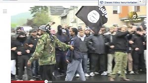 Standbilder aus einem Video von 2012: Als Salafisten mit Steinen, Stöcken und Messern Polizisten in Bonn attackieren,ist der Pforzheimer Munir in erster Reihe dabei – mit der Flagge der Terrororganisation Al Kaida Foto: Screenshot Youtube