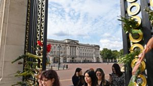 Blumen erinnern an die viel geliebte Queen: Besucherinnen vor den Toren des Buckingham-Palasts in London. Foto: AFP/Alain Jocard