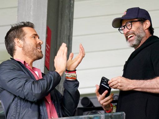 Ryan Reynolds (li.) und Hugh Jackman gut gelaunt auf der Stadiontribüne. Foto: Imago Images/PA Images
