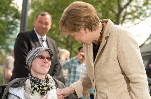 Bundeskanzlerin Angela Merkel (CDU, rechts) spricht bei ihrem Besuch im Deutschen Krebsforschungszentrum (DKFZ) in Heidelberg mit einer Patientin. Foto: dpa