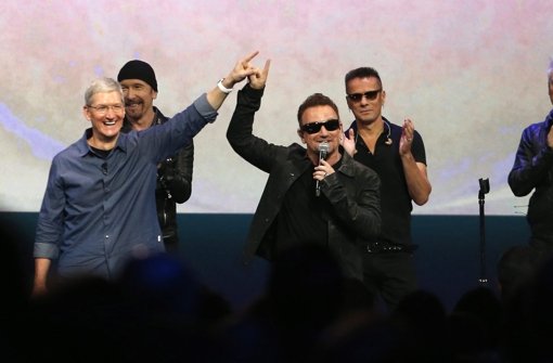 Apple-Chef Tim Cook (links) mit dem Sänger der irischen Rockband Bono (dritter von rechts) bei der Keynote in Cupertino. Foto: dpa