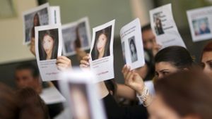 Angehörige und Freunde von Tugce halten vor der Urteilsverkündung Bilder der 22-Jährigen im Gerichtssaal hoch Foto: dpa