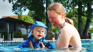 Erste Wasserprobe mit Sonnenschutz und im festen Griff der Mutter: Rafael hat sichtlich Spaß im Becken. Foto: Julia Schenkenhofer