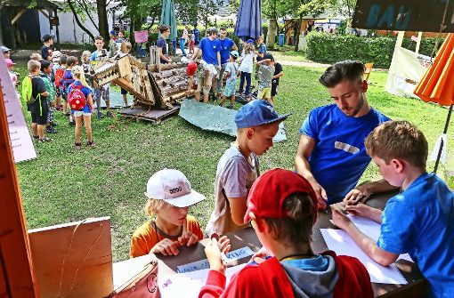 Ein Drache aus Holz entsteht. Eine Gruppe von Kindern befasst sich damit, während andere im Reisebüro Ausflüge verkaufen. Foto: factum/Granville