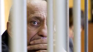 Michail Popkow sieht während der Gerichtsverhandlung durch die Käfigfgtter. Ein Gericht in Irkutsk hat  den 53-Jährigen des Mordes an weiteren 56 Frauen schuldig gesprochen und ihn zu einer lebenslangen Haftstrafe verurteilt. Foto: dpa