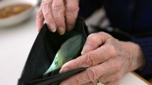 Eine ältere Frau öffnet ihr Portemonnaie. Frauen kommen nach 45 Versicherungsjahren auf eine Rente von durchschnittlich 1323 Euro pro Monat. Foto: Stephanie Pilick/dpa/Stephanie Pilick