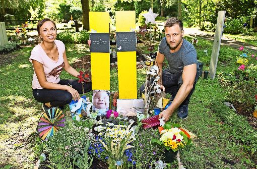 Hannah und Thorsten Stecker legen die neue Box aufs Grab ihrer Kinder. Foto: Lg/Willikonsky