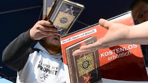 Ein Mann verteilt in der Innenstadt von Hannover kostenlose Koran-Exemplare an Passanten Foto: dpa