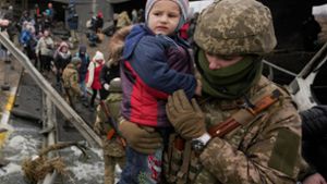 Bilder dieses Krieges: Ein ukrainischer Soldat bringt ein Kind aus dem umkämpften Irpin in Sicherheit. Foto: dpa//adim Ghirda