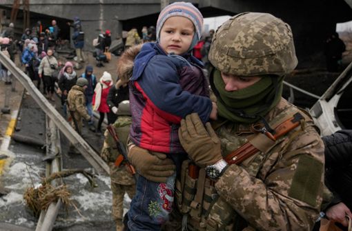 Bilder dieses Krieges: Ein ukrainischer Soldat bringt ein Kind aus dem umkämpften Irpin in Sicherheit. Foto: dpa//adim Ghirda