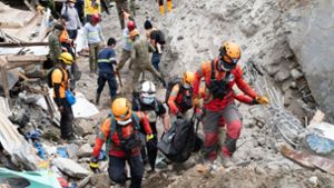 Rettungskräfte tragen ein Opfer aus dem von einem Erdrutsch betroffenen Dorf Masara. Die Zahl der Toten stieg auf 37. Foto: Uncredited/AP/dpa