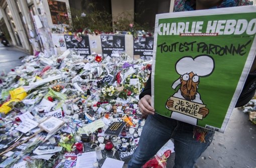 Blumenberge nach dem Anschlag auf „Charlie Hebdo“ im Januar – ist das Satire-Magazin mit der Karikatur eines Flüchtlingskinds jetzt zu weit gegangen? Foto: dpa