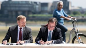 Politidylle: Christian Lindner (FDP/links) und Armin Laschet (CDU) unterzeichnen unter den Augen einer interessierten Bürgerin den Koalitionsvertrag. Foto: dpa