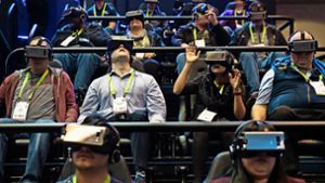 Was diese Menschen wohl sehen? Am Stand des Elektronikkonzerns Samsung probieren CES-Messebesucher  VR-Brillen aus. Foto: AP, dpa  (2)