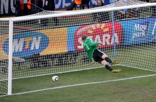 WM 2010: Der deutsche Nationaltorwart Manuel Neuer steht in der Luft und sieht den Ball hinter sich auf den Boden fallen. Der Schuss des englische Spielers Frank Lampard kommt hinter der Linie auf, der Schiedsrichter lässt aber weiterspielen. Foto: dpa
