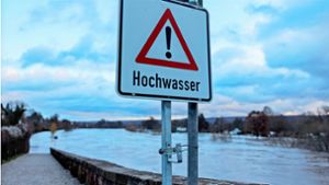 Hochwasser· steht auf einem Schild an der Weserbrücke in Nordrhein-Westfalen. Foto: dpa/Friso Gentsch