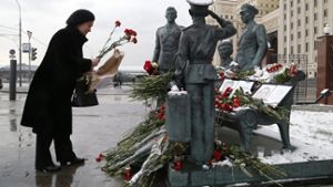 Eine Frau legt Blumen an einem Denkmal für gefallene Soldaten nieder. Foto: dpa