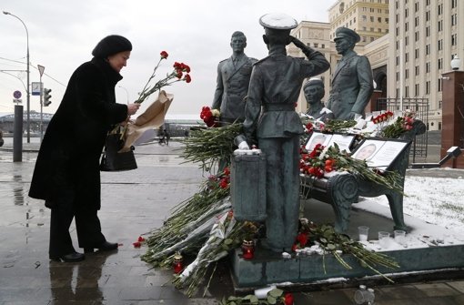 Eine Frau legt Blumen an einem Denkmal für gefallene Soldaten nieder. Foto: dpa