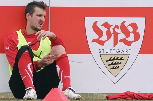 Zdravko Kuzmaovic sitzt auf dem Trainingsplatz an der Bande mit dem Wappen des VfB Stuttgart.  Foto: Pressefoto Baumann