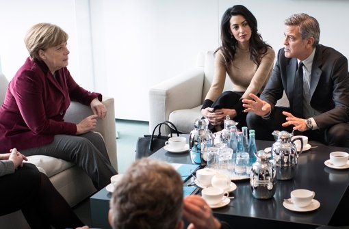 George Clooney (r.) und seine Frau Amal (Mitte) haben sich mit Angela Merkel (l.) getroffen. Foto: dpa/Bundespresseamt