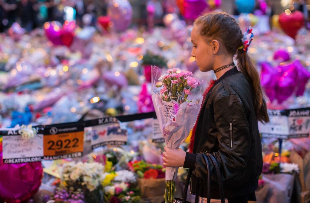 Ein Mädchen legt in Manchester Blumen für die Opfer des Anschlags nieder.